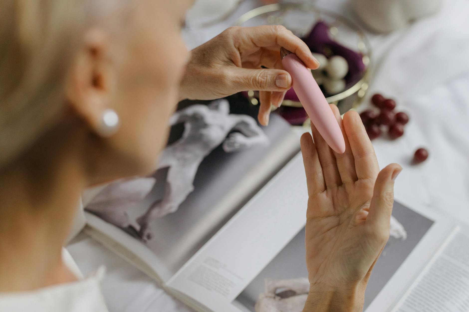 Woman holding blue and pink vibrators contemplatively, representing different pleasure responses with hormonal IUDs